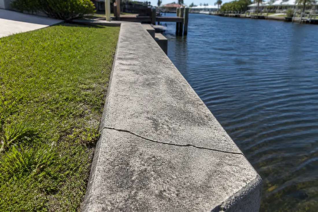 A crack running across the top of a concrete seawall cap